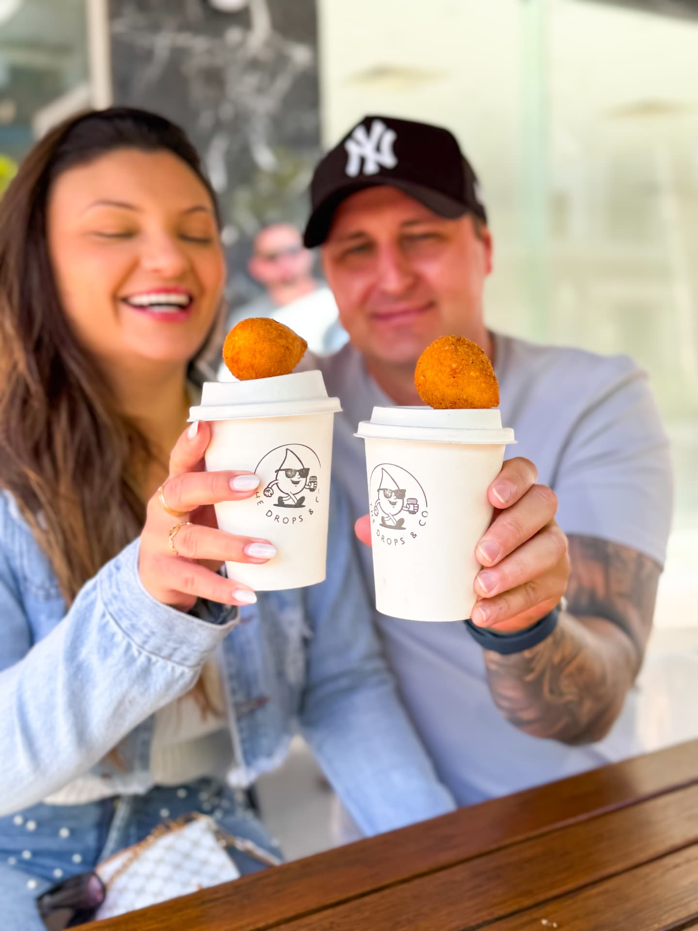 Family holding The Drops coffee cups with coxinhas